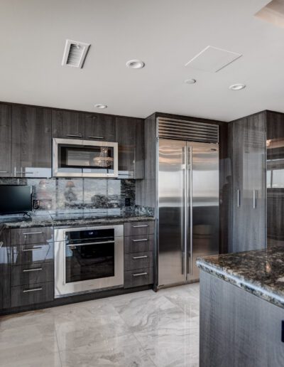 A kitchen with marble counter tops and stainless steel appliances.