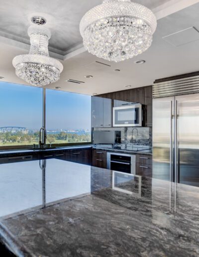 A kitchen with marble counter tops and a chandelier.