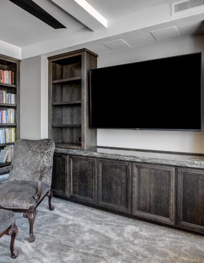 A living room with bookshelves and a tv.