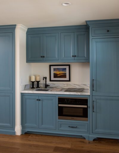 A kitchen with blue cabinets and a microwave.