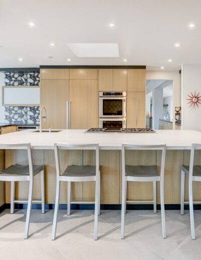 A modern kitchen with a large island and bar stools.