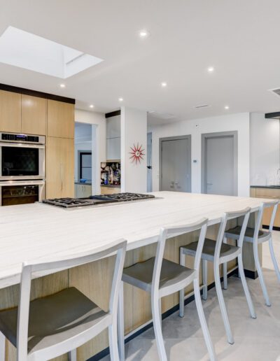 A modern kitchen with a large island and bar stools.