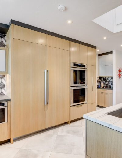 A kitchen with marble counter tops and stainless steel appliances.