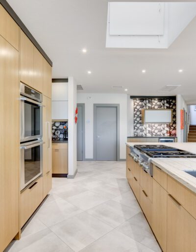 A modern kitchen with wooden cabinets and a skylight.